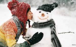 Девушка целует снеговика