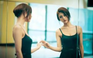 Девушка в танцевальном зале у зеркала
